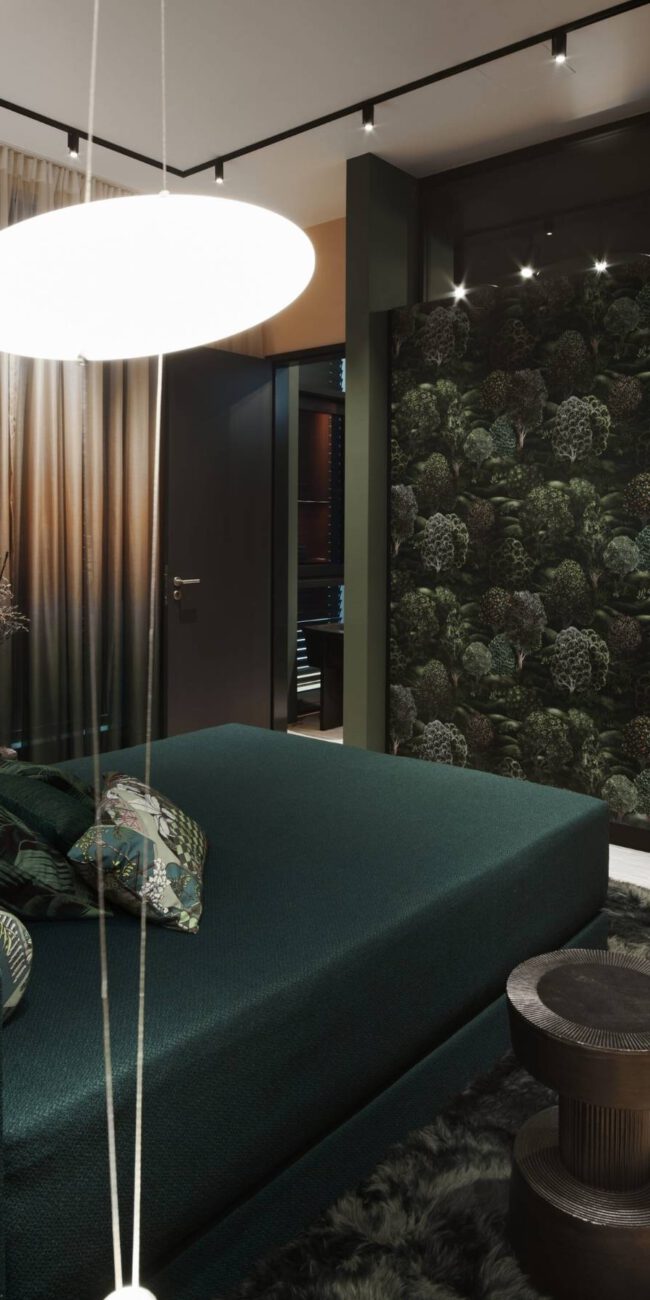 Schlafbereich mit dunkelgrünem Bett, Blätter-Tapete und Pendelleuchte im Business Apartment