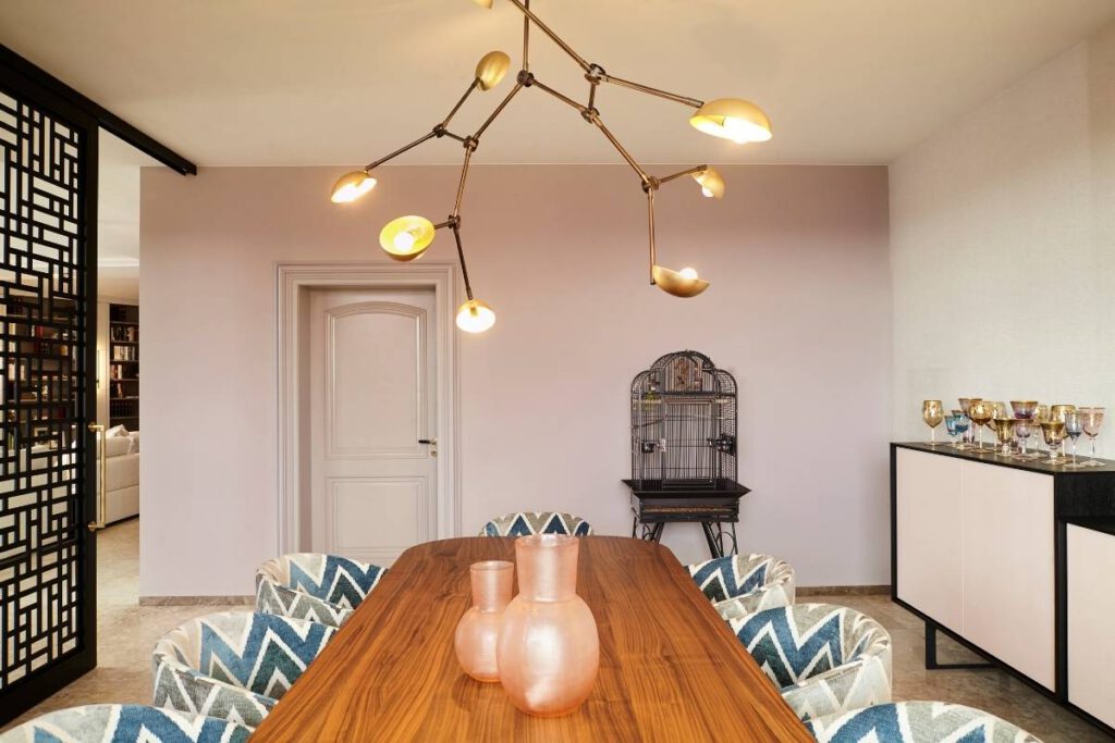 Nussbaum-Esstisch mit Zickzack-Stühlen unter Messing-Pendelleuchte im Esszimmer der Villa A