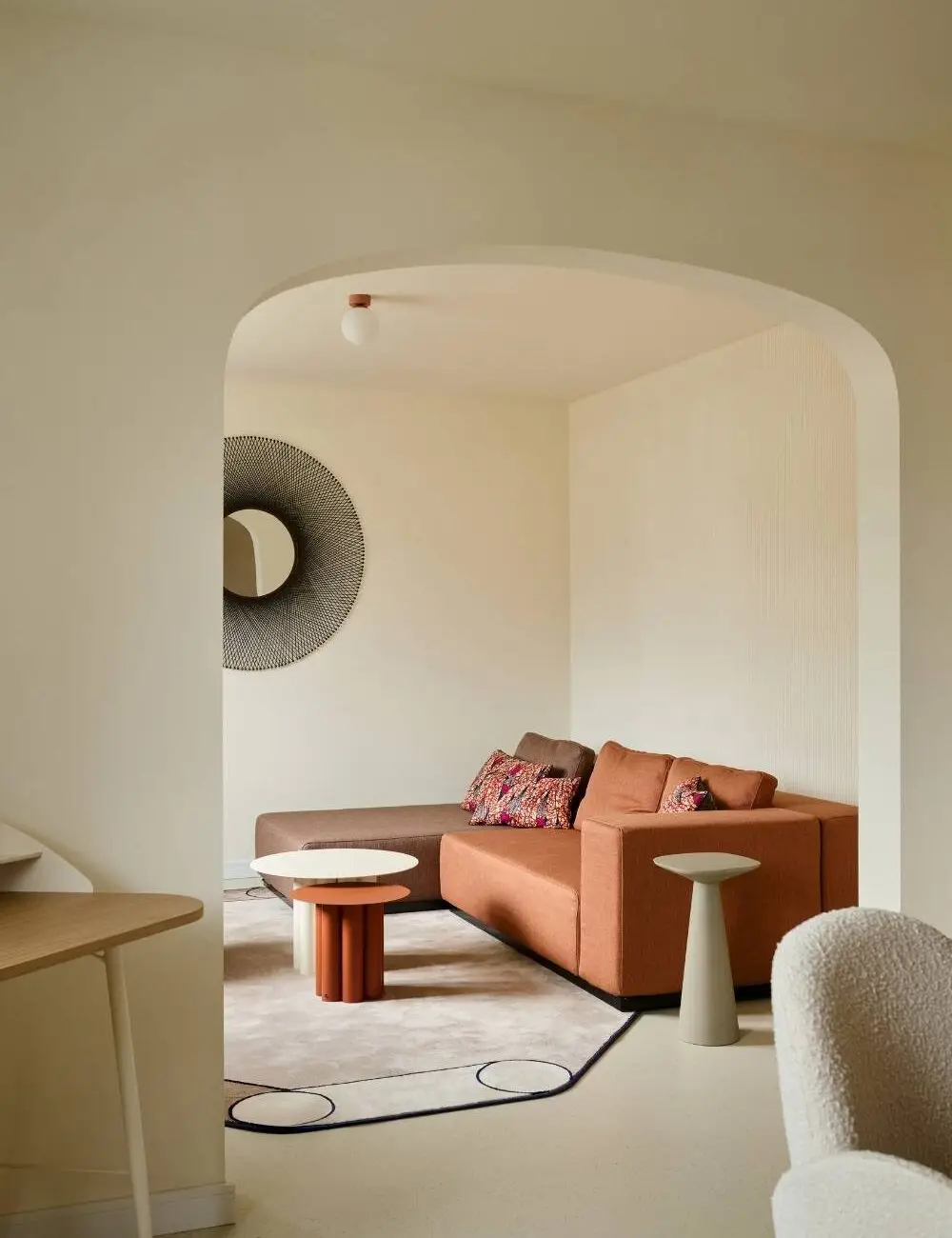 Rostrotes Sofa mit Beistelltischen und Spiegel im Rundbogenzimmer der Villa Haag