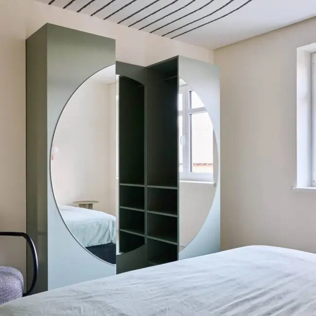 Salbeigrüner Schrank mit rundem Spiegel und Linien-Deckenmalerei im Schlafzimmer, Villa Haag