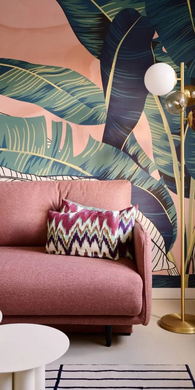 Rosa Sofa vor tropischer Blätter-Tapete mit Messing-Stehleuchte in der Villa Haag