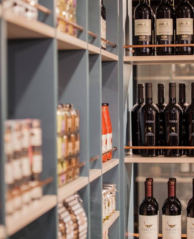 Regale mit Weinflaschen, Feinkost und kupferfarbener Wandverkleidung in Brunos Bistro