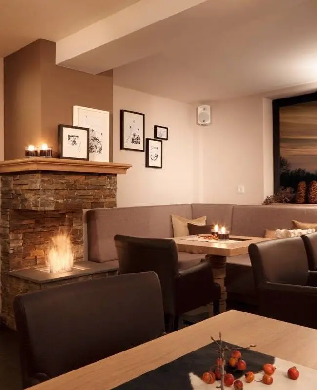 Gemütliche Ecke mit Kamin, Polsterbank und Bildergalerie im Hotel Taufstein Restaurant I