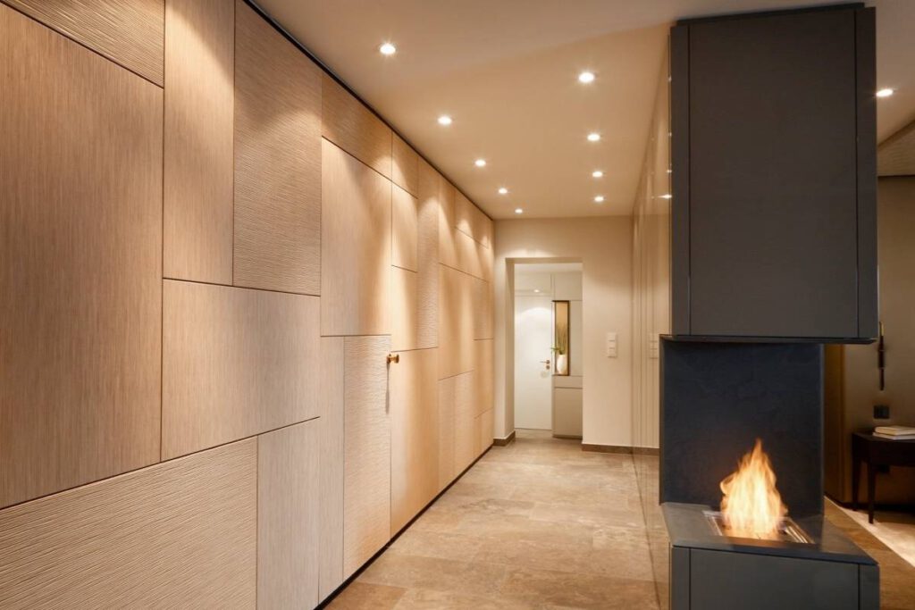Flur mit Holzwandpaneelen, Einbauschränken und doppelseitigem Kamin in der Suite A