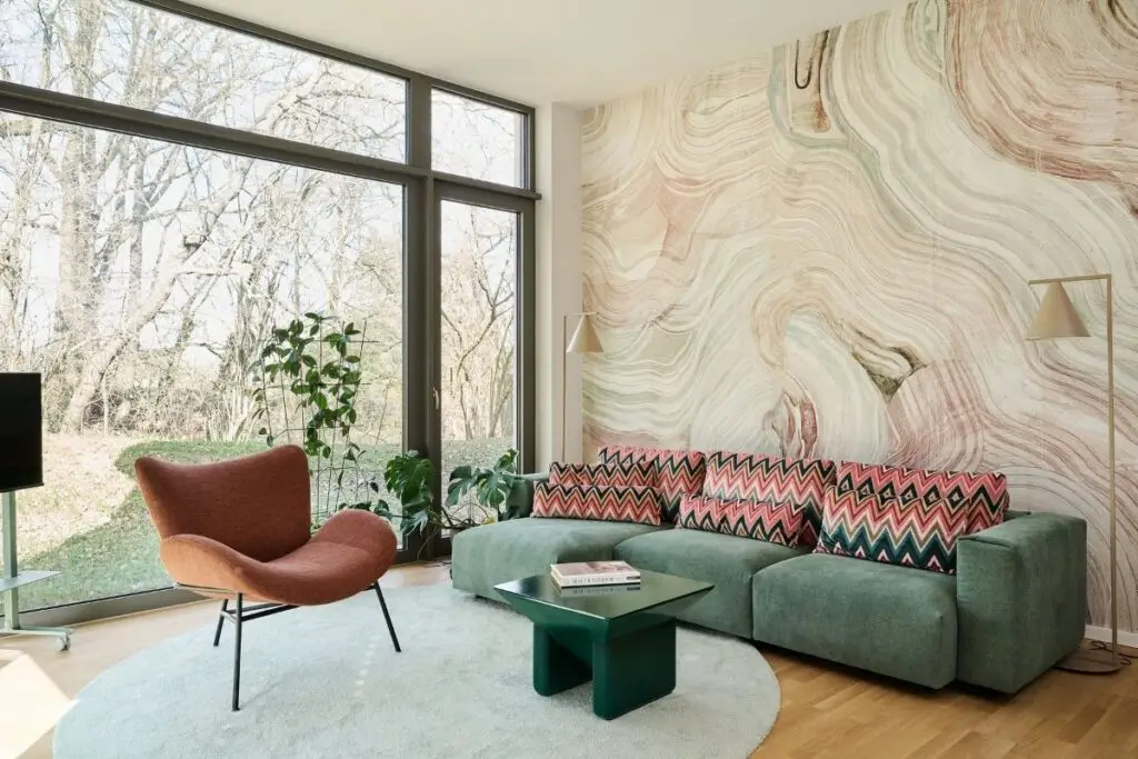 Wohnzimmer mit grünem Sofa und Marmor-Wandtapete in einer Einliegerwohnung in Fulda