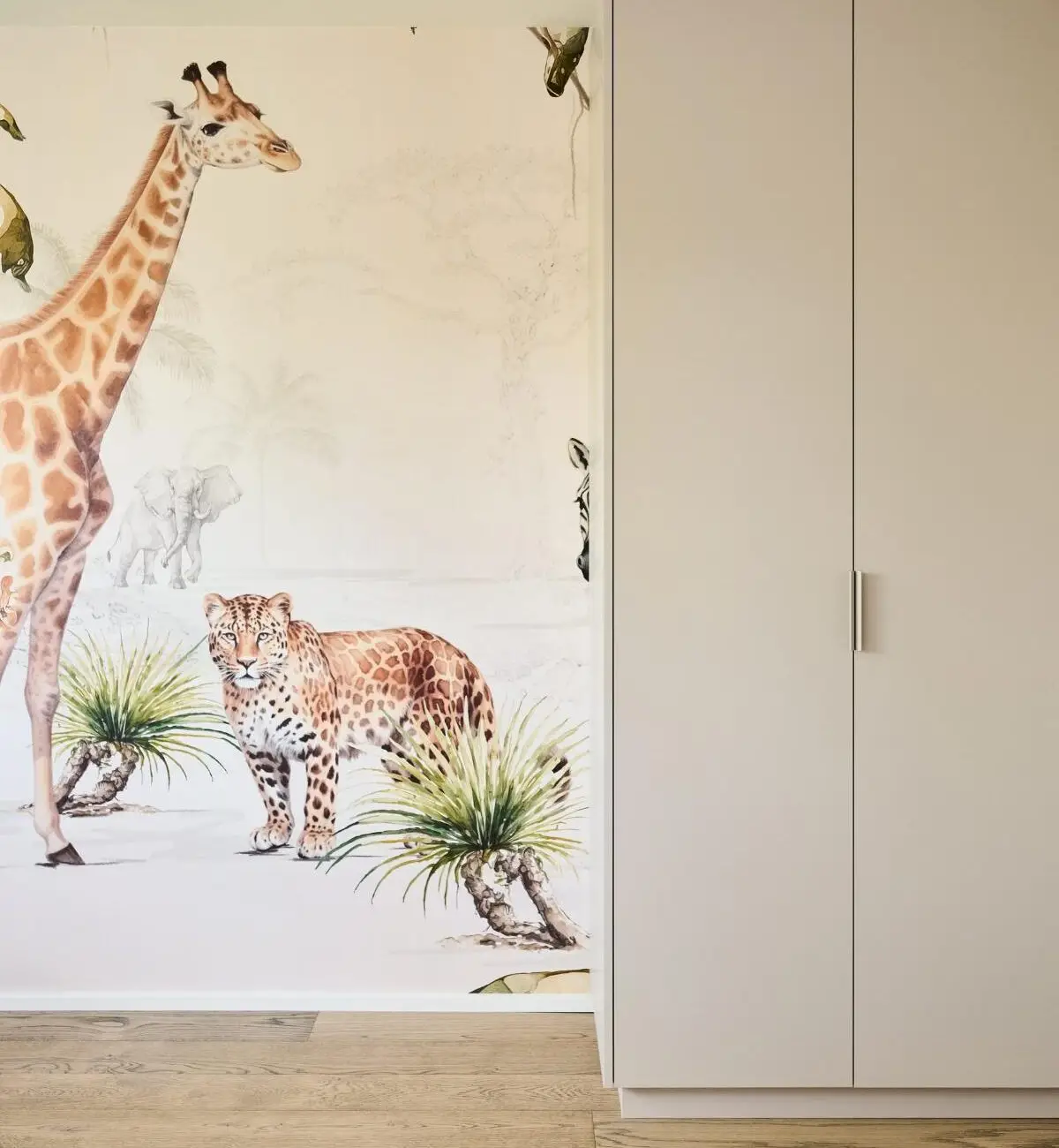 Kinderzimmer mit Wandtapete aus Giraffe und Leopard neben weißem Schrank im Haus R in Fulda