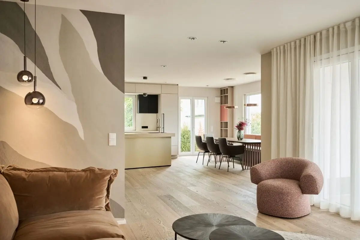 Offener Wohnraum mit Samtsofa, rosa Sessel und Blick zur Küche im Haus R in Fulda