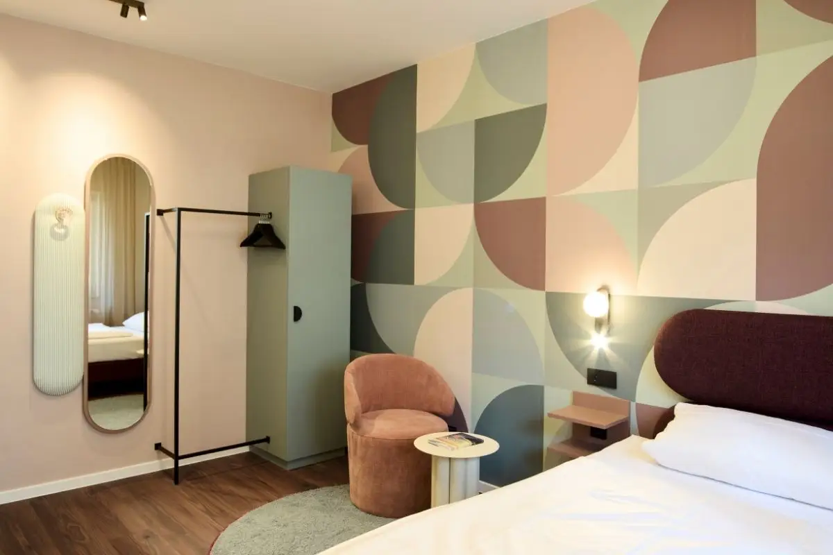 Hotelzimmer mit geometrischer Wandtapete in Rosé und Salbei im Gästehaus 2, Haus der Standesbeamten