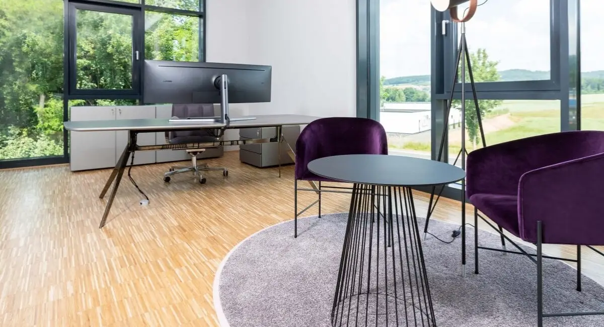 Chefbüro mit Schreibtisch am Fenster und violetten Sesseln auf rundem Teppich, Belfox