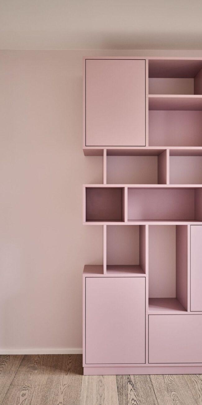 Detail einer rosa lackierten Regalwand mit Schranktüren im Haus R in Fulda