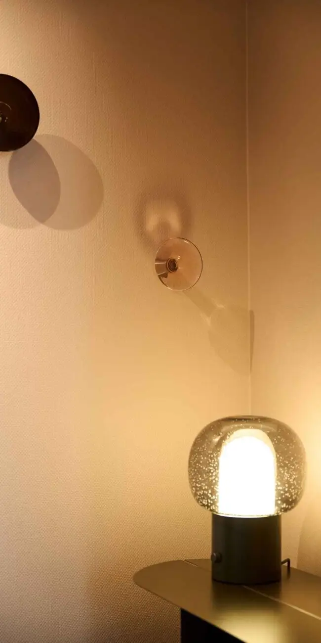 Glas-Tischleuchte und Wandleuchten in warmem Licht im Gästehaus 2, Haus der Standesbeamten