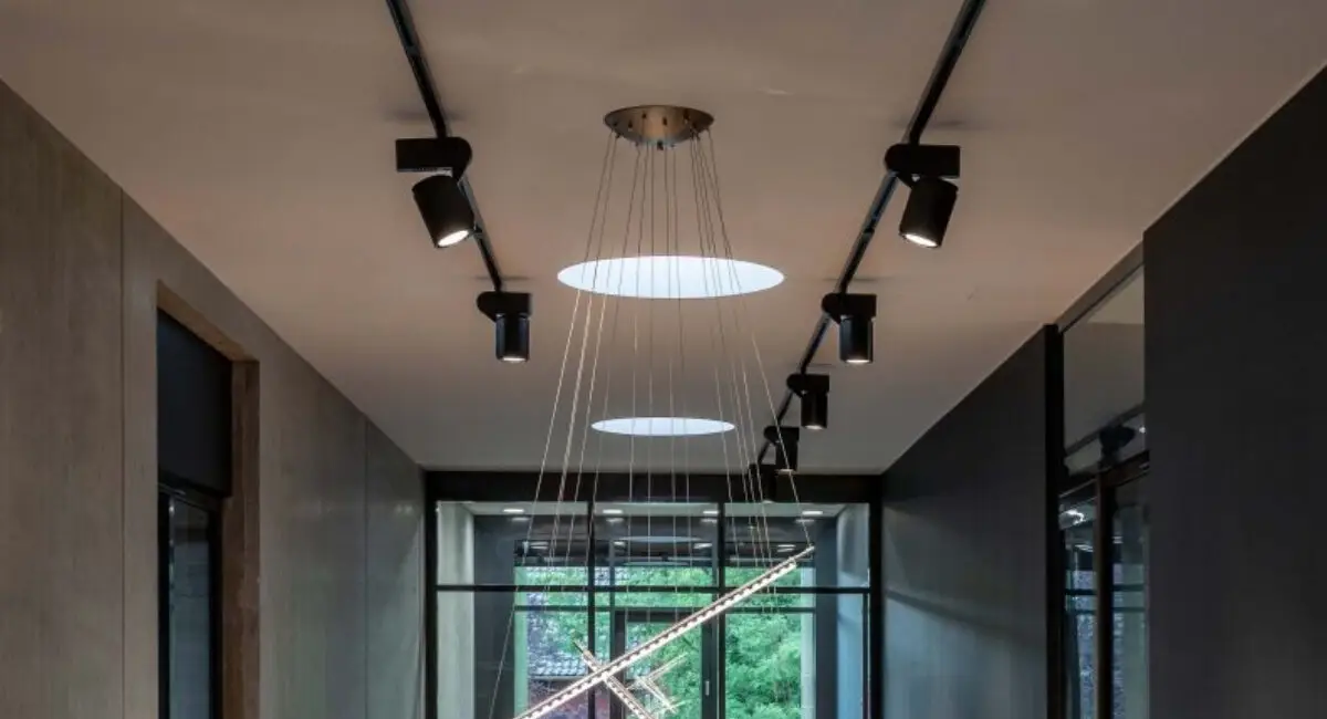 Galerie mit Stahlgeländer, Strahlerschienen und filigraner Pendelleuchte unter Oberlicht bei Belfox