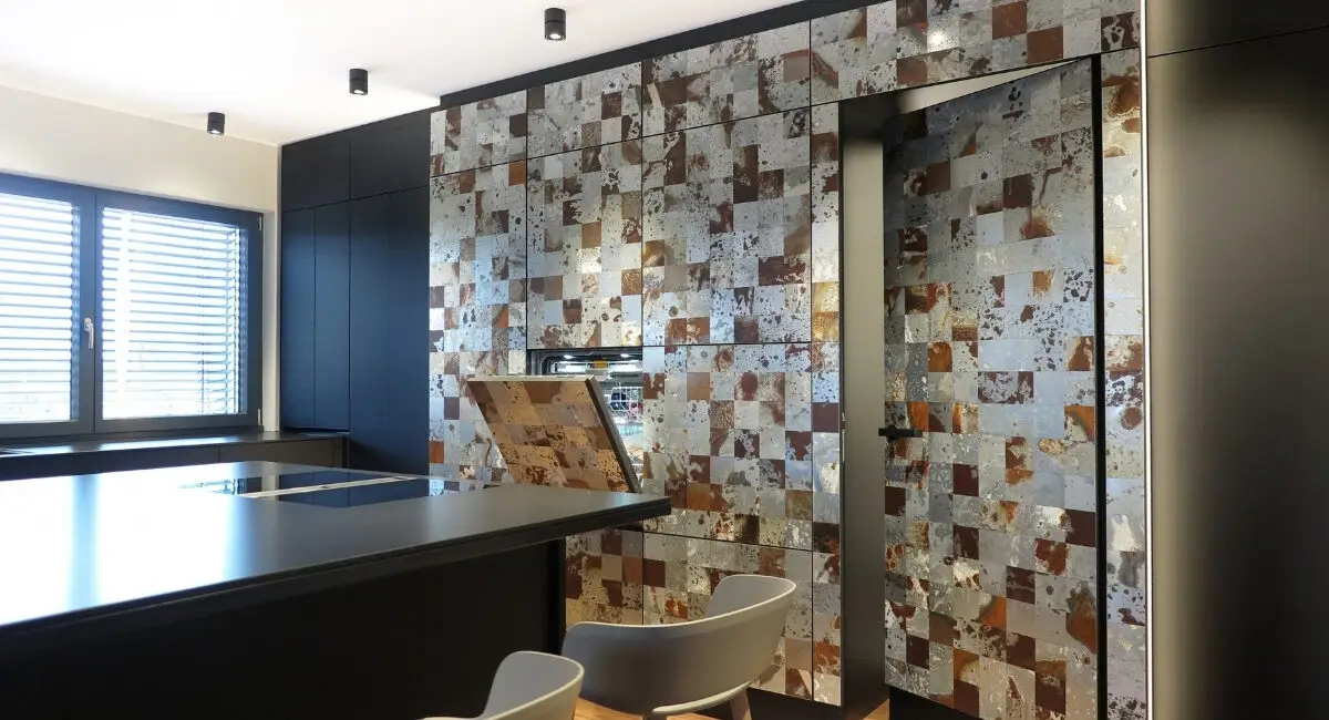 Hochschrankwand mit Fliesenmosaik und offener Klappe neben Kochinsel im Haus S