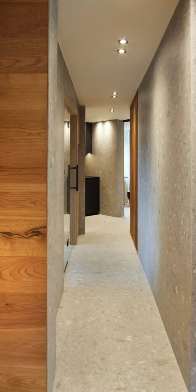 Schmaler Gang mit Terrazzowänden und Eichenholz in der Private Wellness Suite