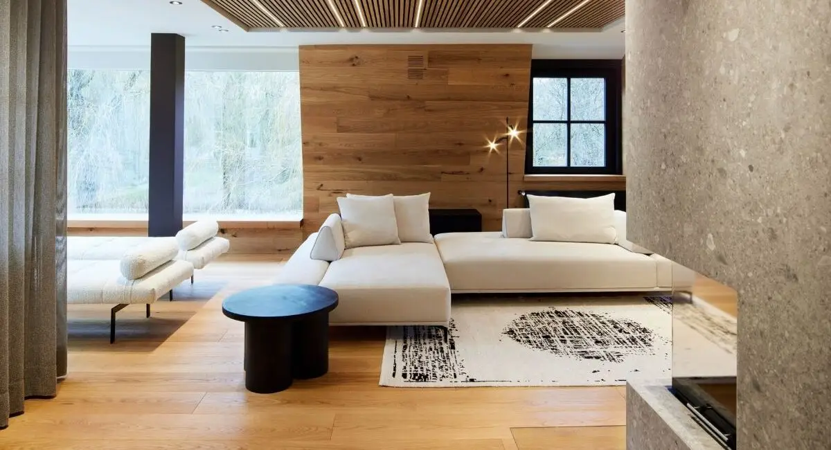 Wohnbereich der Private Wellness Suite mit Holzdecke und Sofa – RAUM+INHALT