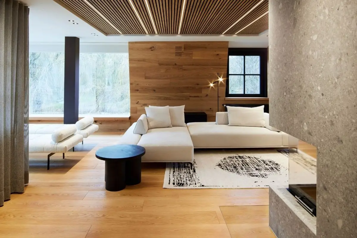 Wohnbereich der Private Wellness Suite mit Holzdecke und Sofa – RAUM+INHALT