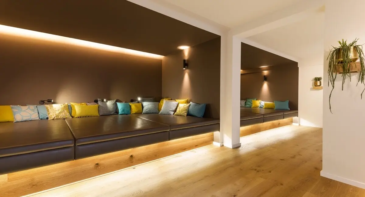 Lange Liegenische mit Lederpolstern, bunten Kissen und indirektem Licht im Taufstein Spa