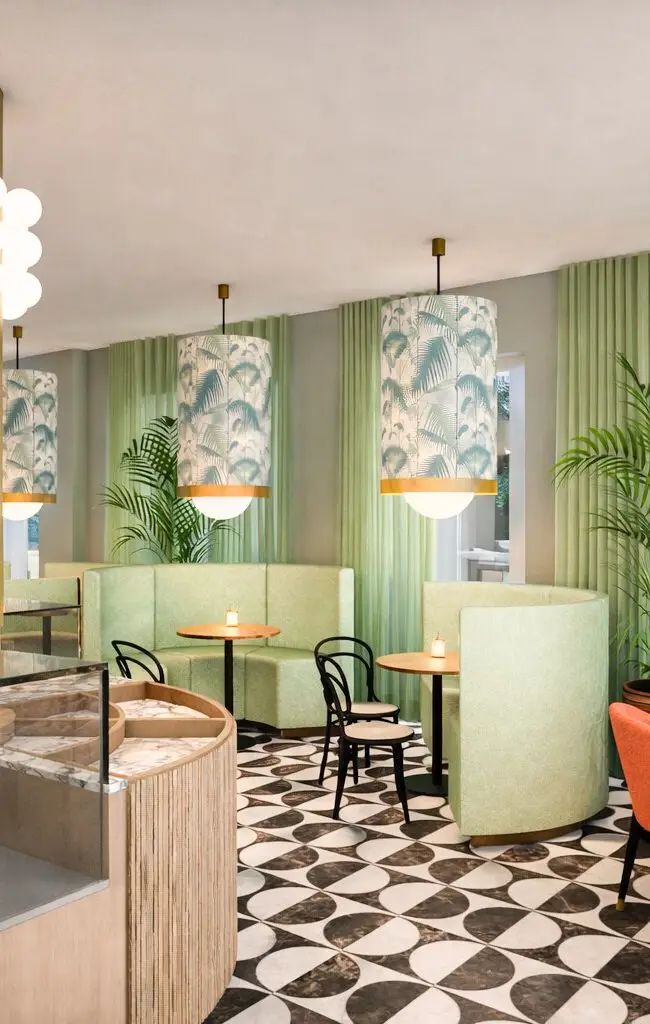 Visualisierung: Messingsäulen, grüne Vorhänge und Sitzgruppen mit orangefarbenen Stühlen, Café Studie