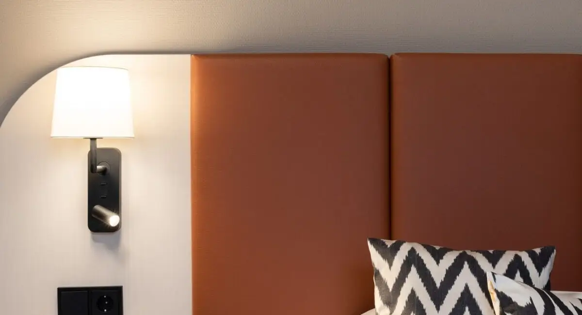 Kopfteil in Cognac mit Wandleuchte und Zickzack-Kissen, Haus der Standesbeamten Haus 3