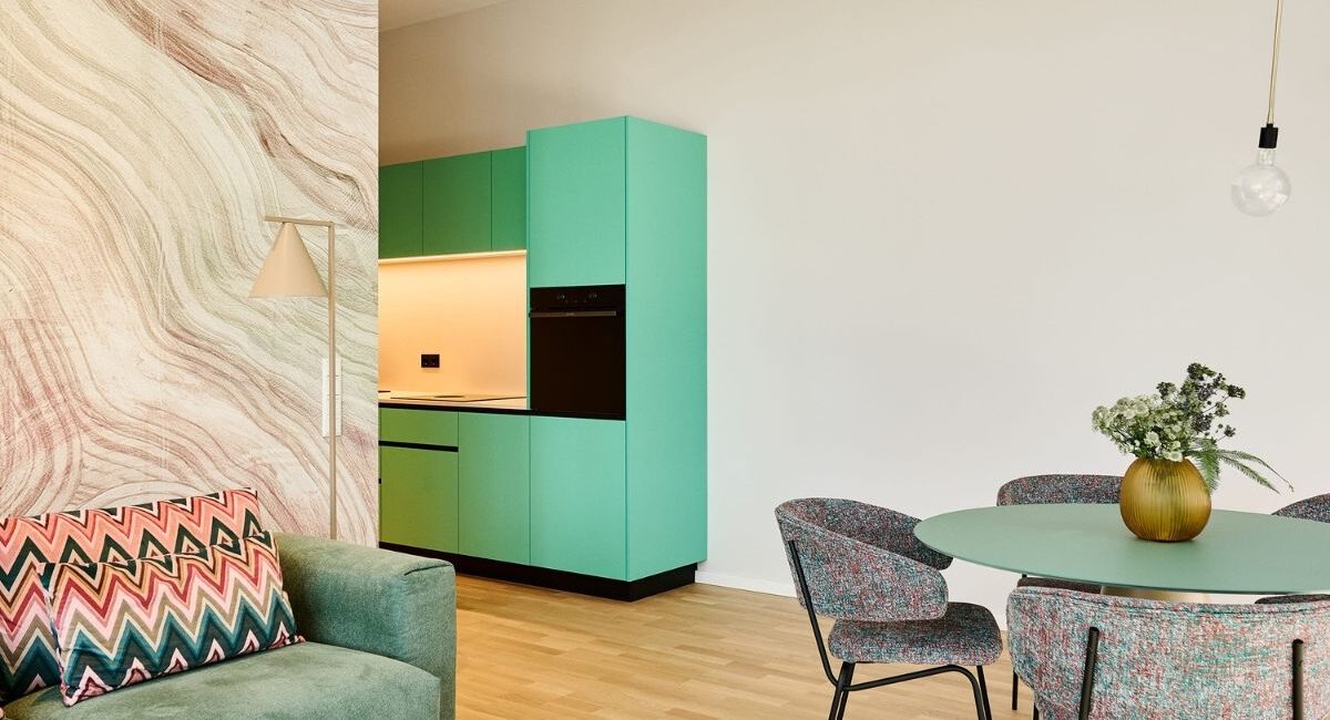 Wohn- und Essbereich mit grünem Couchtisch und runder Essgruppe in der Ferienwohnung