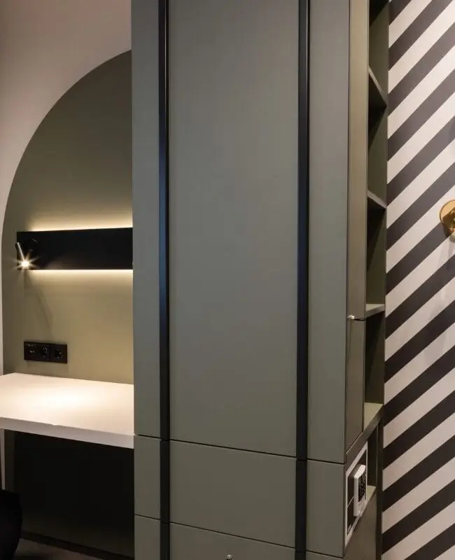 Schreibtisch in Bogennische neben grünem Schrank und Streifenwand, Haus der Standesbeamten Haus 3