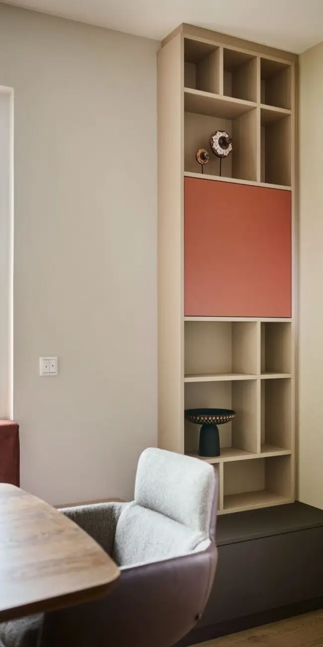 Regalwand aus Holz mit terrakottafarbener Klappe neben Essplatz im Haus R in Fulda