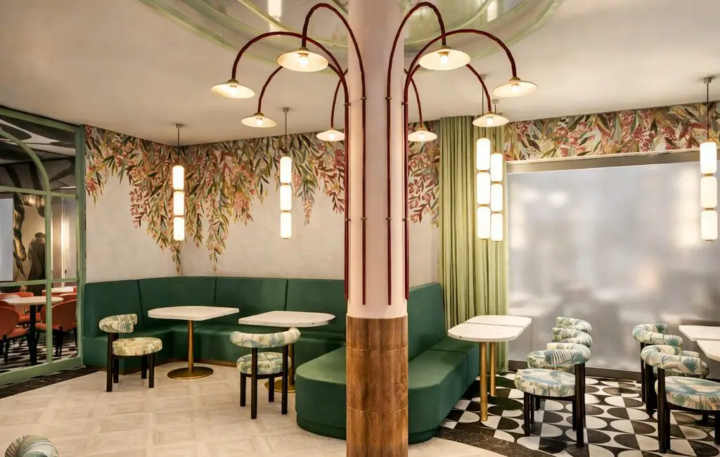 Visualisierung: Grüne Polsterbank und Bogenleuchten vor floraler Wandtapete in der Café Studie