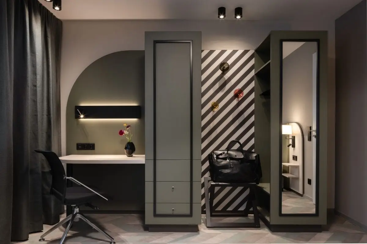 Hotelzimmer mit Schreibtischnische, grünem Schrank und schwarz-weißer Streifenwand, Haus der Standesbeamten Haus 3