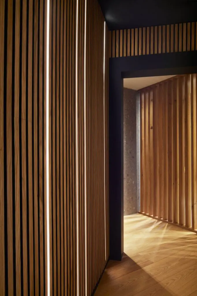 Durchgang mit Holzlamellen und Lichtstreifen in der Private Wellness Suite