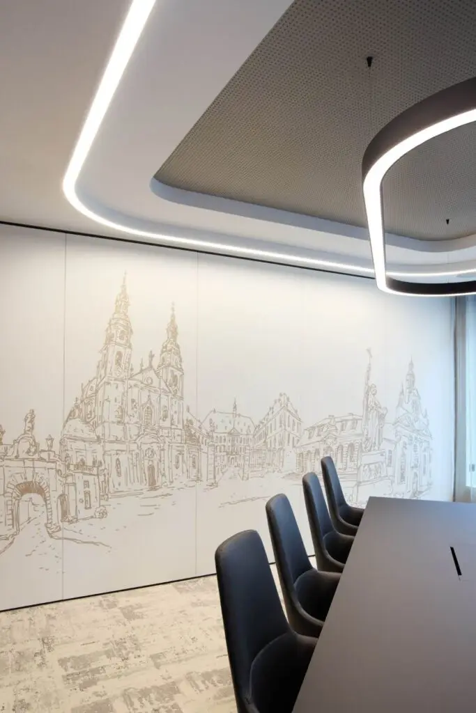 Besprechungsraum mit Stadtansicht als Wandgrafik und schwarzen Stühlen bei Alt & Partner
