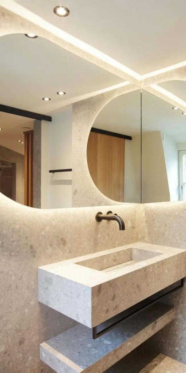 Waschtisch aus Terrazzo mit zwei beleuchteten Rundspiegeln in der Private Wellness Suite