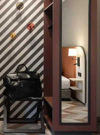 Garderobe mit Ledertasche vor schwarz-weißer Streifenwand im Haus der Standesbeamten Haus 3