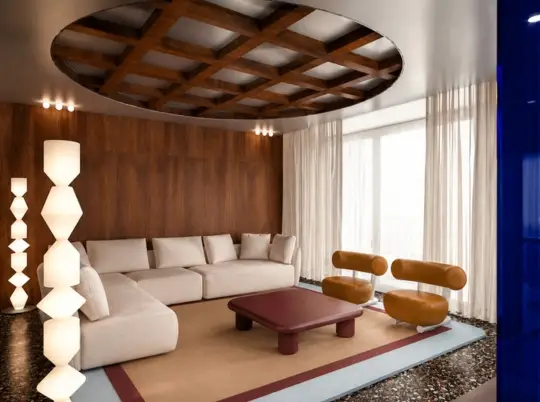 Wohnzimmer mit Kassettendecke, Ecksofa und orangefarbenen Sesseln in der Villa W