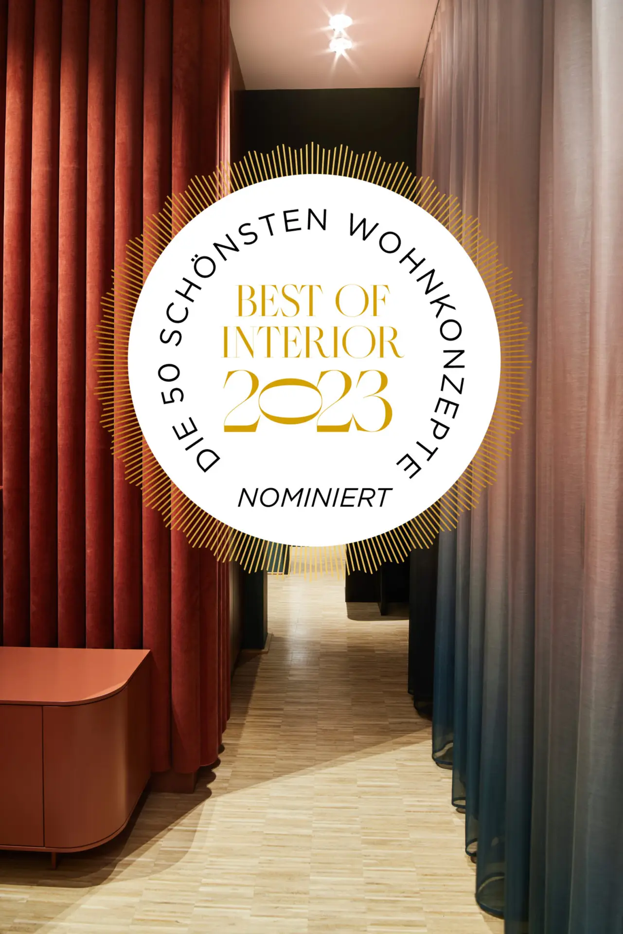 Siegel „Best of Interior 2023 – Nominiert“ vor rotem Vorhang im Business Apartment